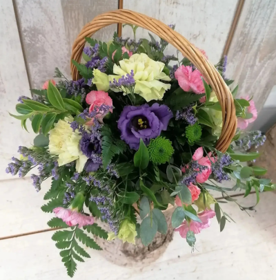Rustic Meadow Basket - A charming countryside-inspired arrangement presented in a classic woven basket. This design features a delightful mix of soft pinks, creamy whites, fresh greens, and pops of lavender and purple blooms, creating a natural, just-picked-from-the-garden feel. Accented with textured foliage and delicate filler flowers, it’s perfect for thoughtful gifting, seasonal celebrations, or adding a warm, rustic touch to any space.