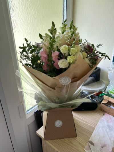 Graceful Elegance - A beautifully arranged display of soft seasonal blooms presented in a stylish container, perfect for sending thoughtful wishes on any occasion.